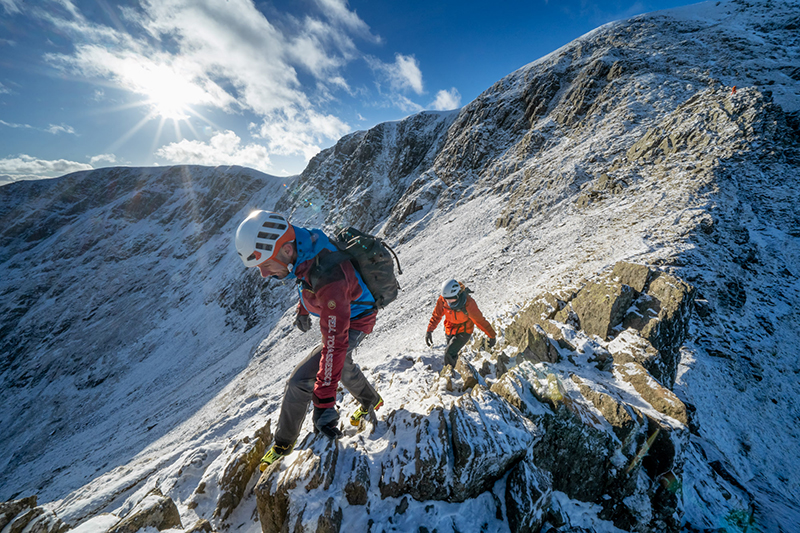 two people on hellvellyn in the snow with helmets on